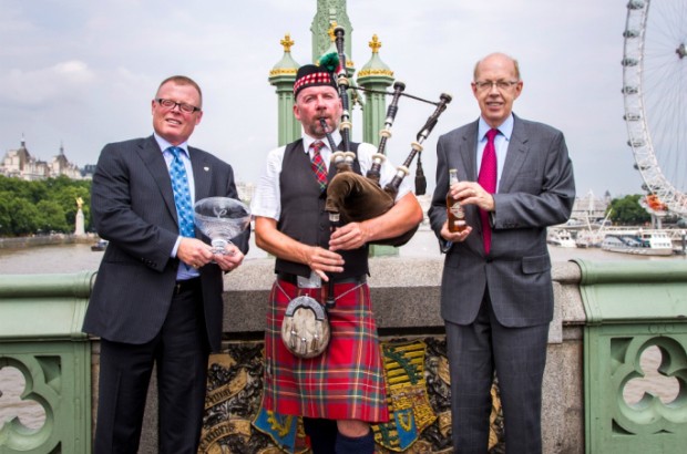 Tony Hunt and Peter Mielzynski from The Innis & Gunn Brewing on Westminster Bridge with a bagpiper