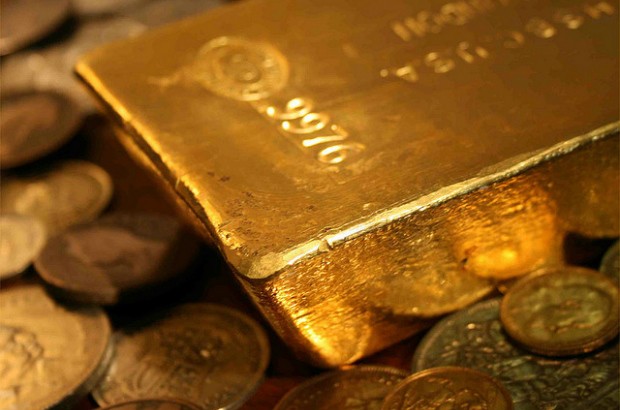 Gold bullion bar in sea of coins.