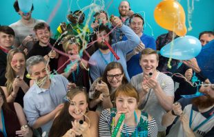 Twinkl team with party poppers and balloons.